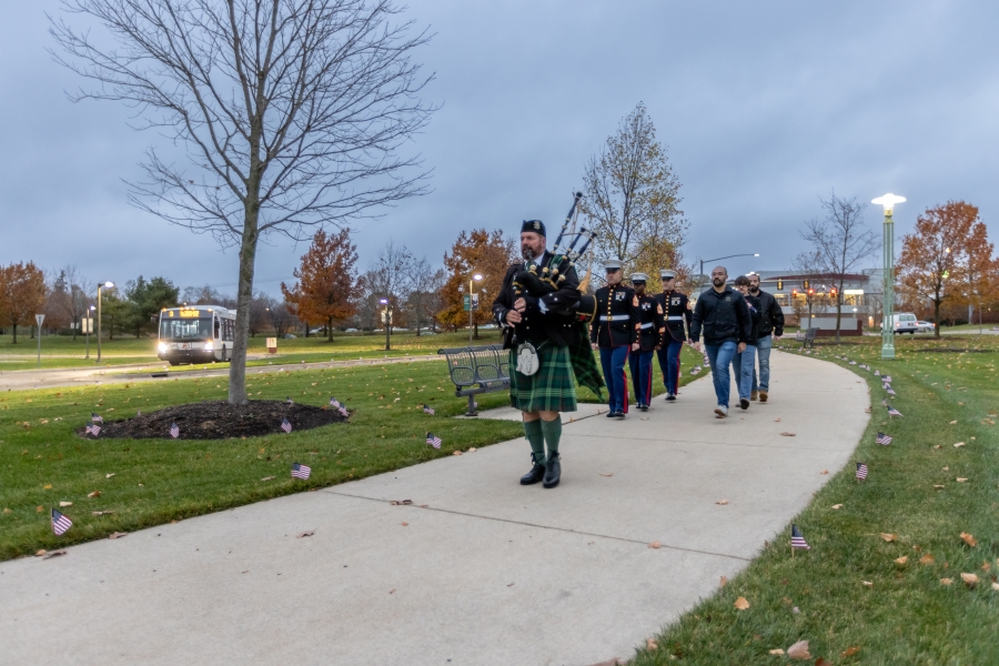 A group of veterans walks towards the flag on the WCC campus.