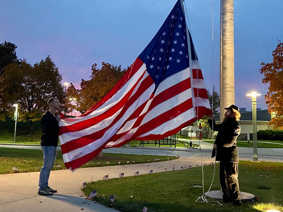 Student veterans raise the flag at a sunrise Veteran’s Day service at Washtenaw Community College. Photo by J.D. Scott