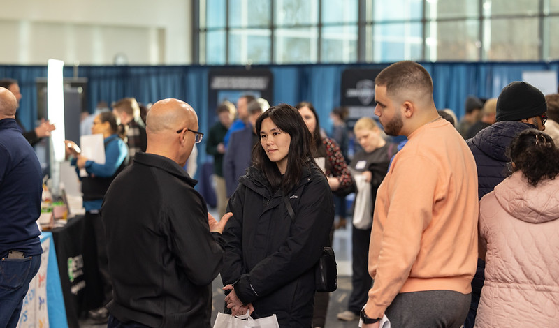 Career fair participants speak with an employer